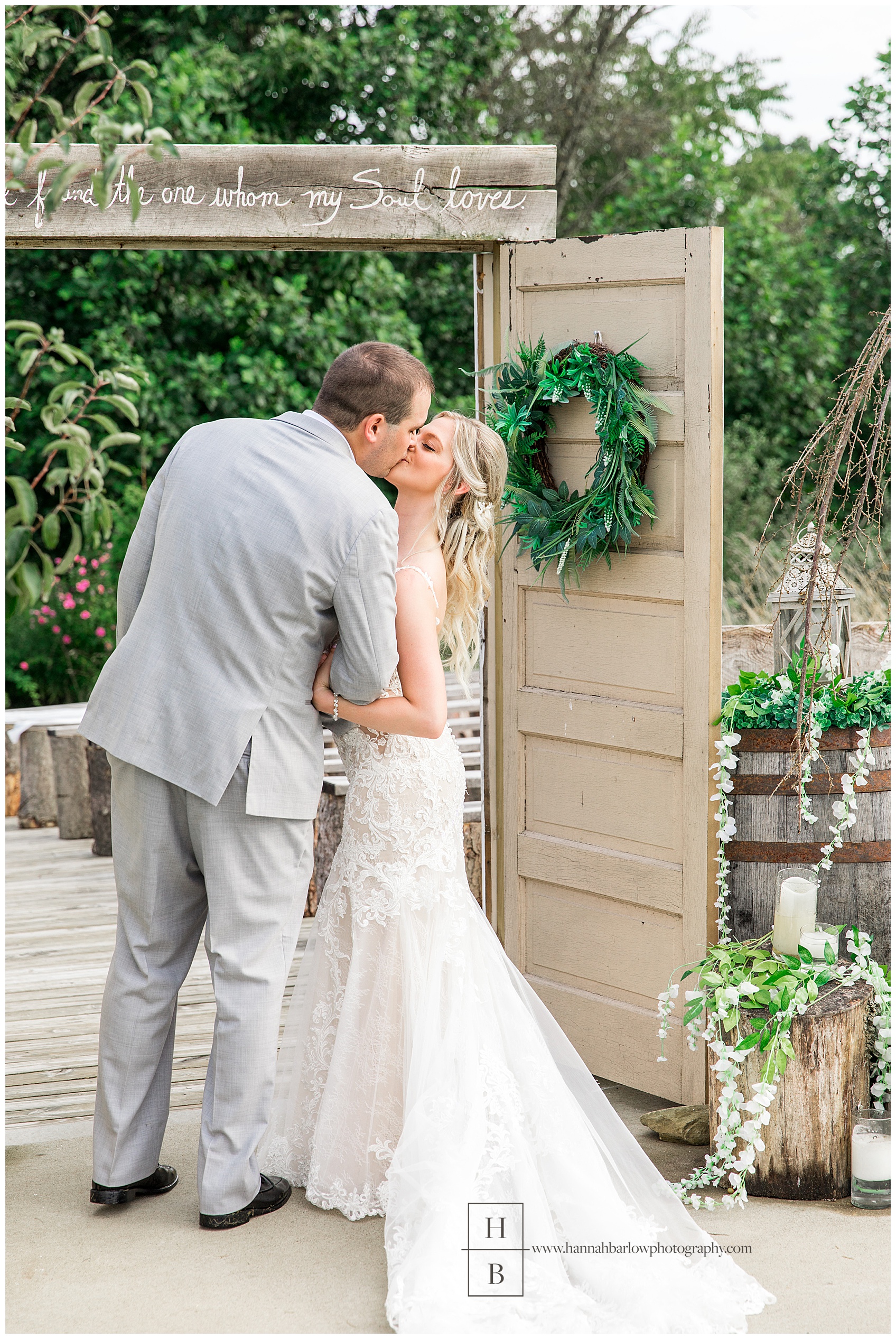 Bride and Groom Kissing by Door at The Barn on Enchanted Acres