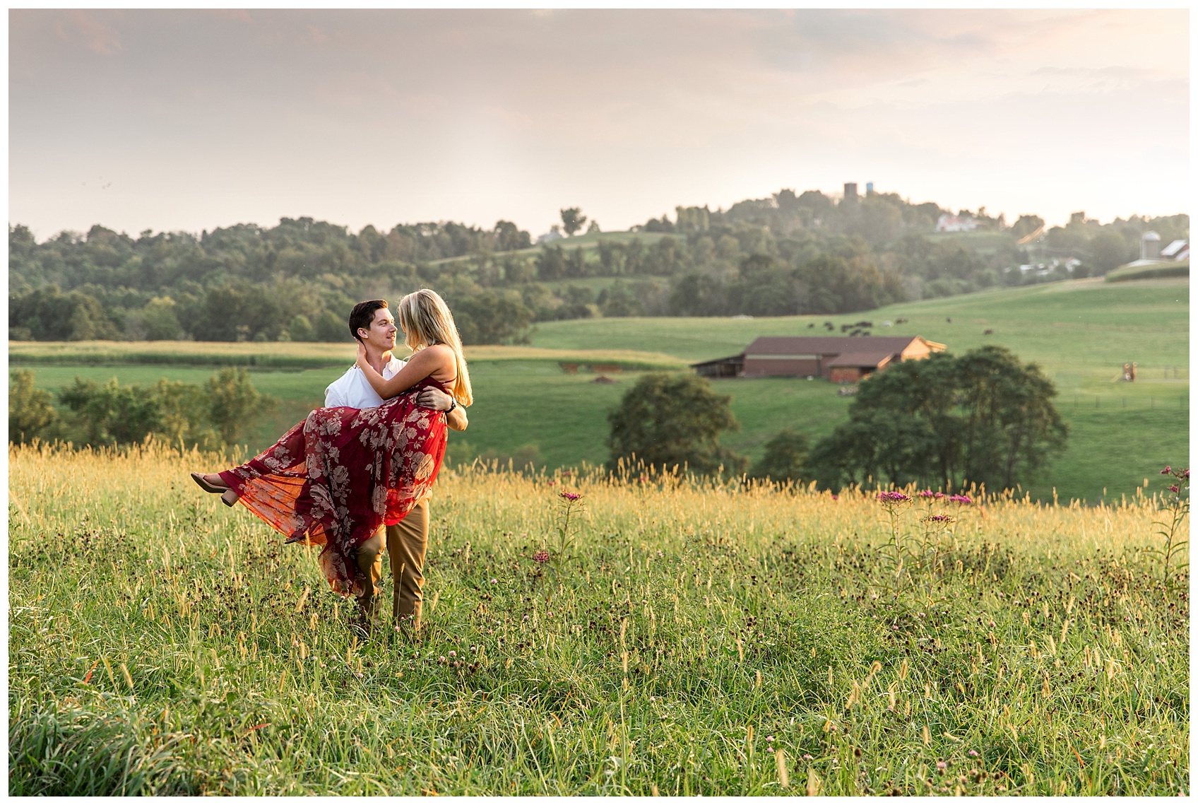 Fiance carrying Bride through Field