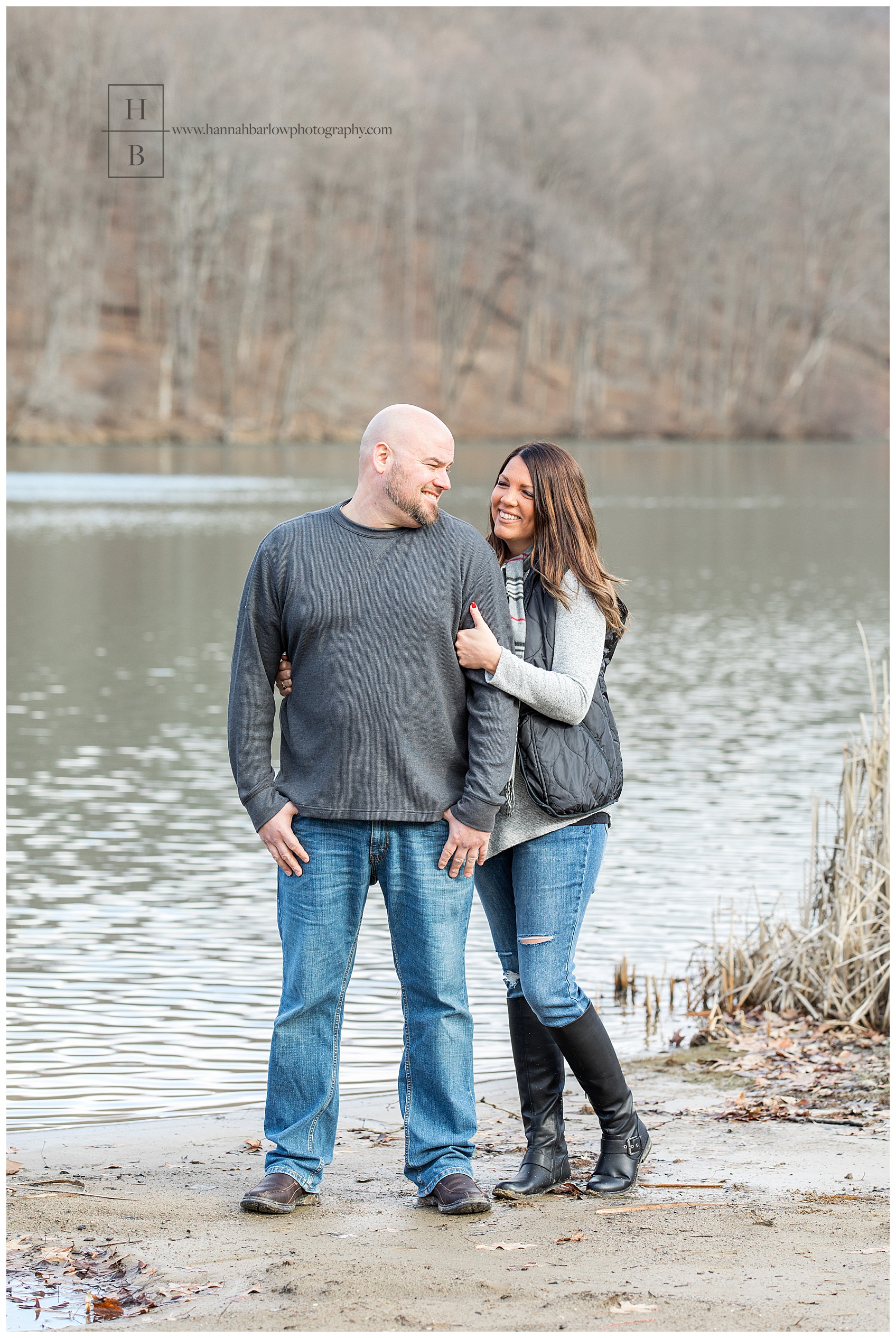 Couple Posing for Engagement Photos by Lake