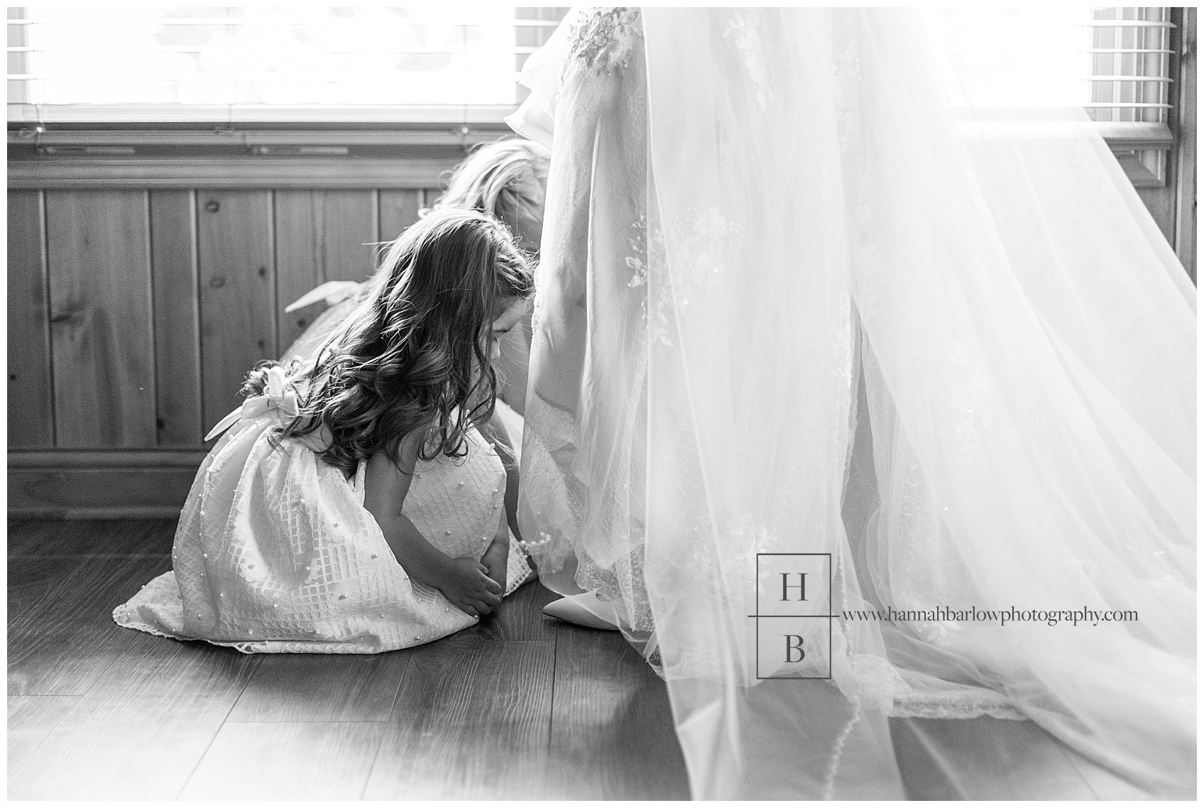 Black and White Photo of Flower Girls Helping Bride Put on Shoes