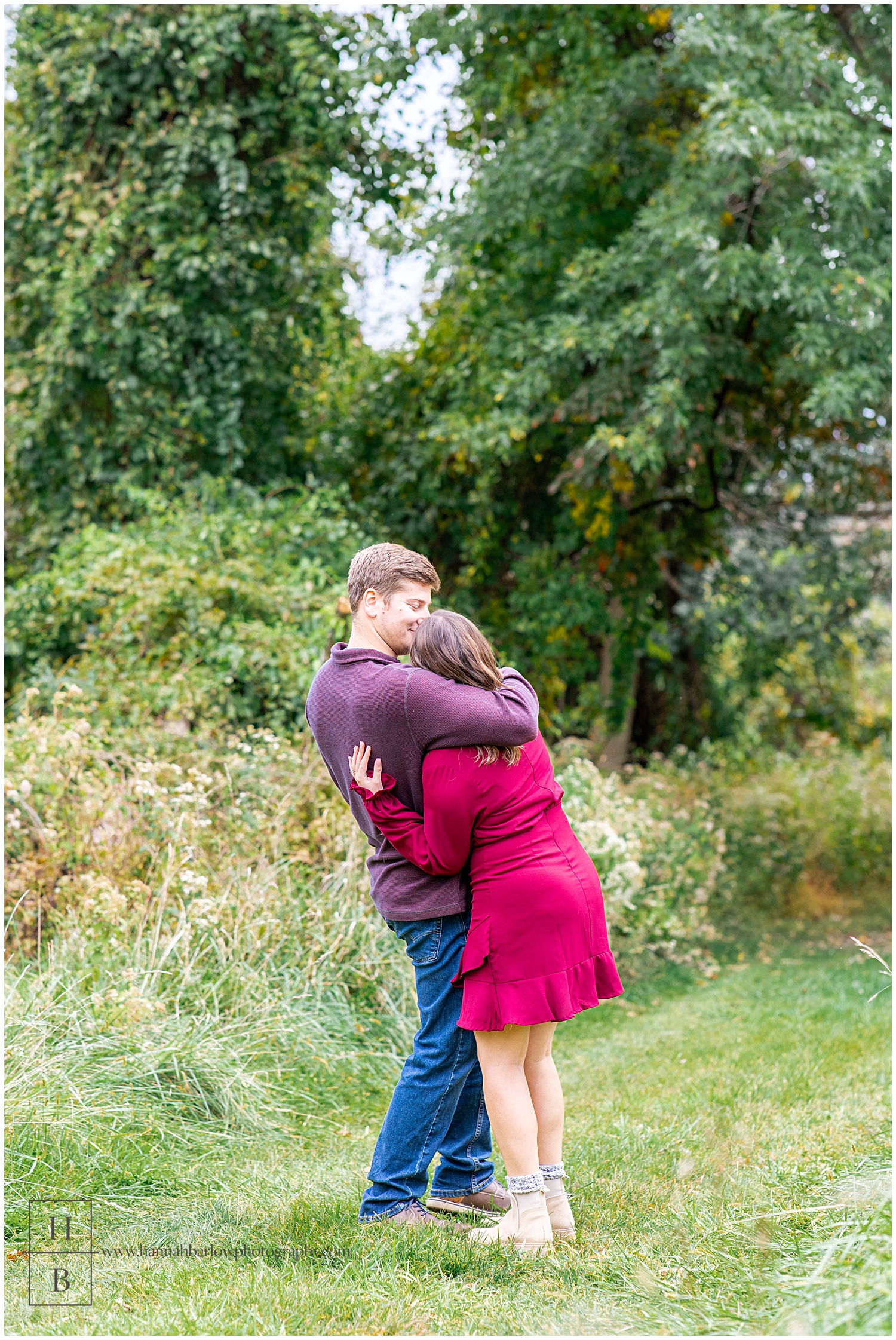 Groom hugging future bride wearing red dress