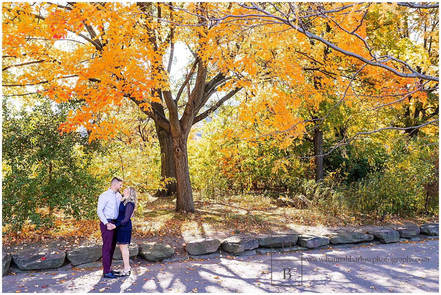 Couple Standing Embracing by Large Orange Fall Tree