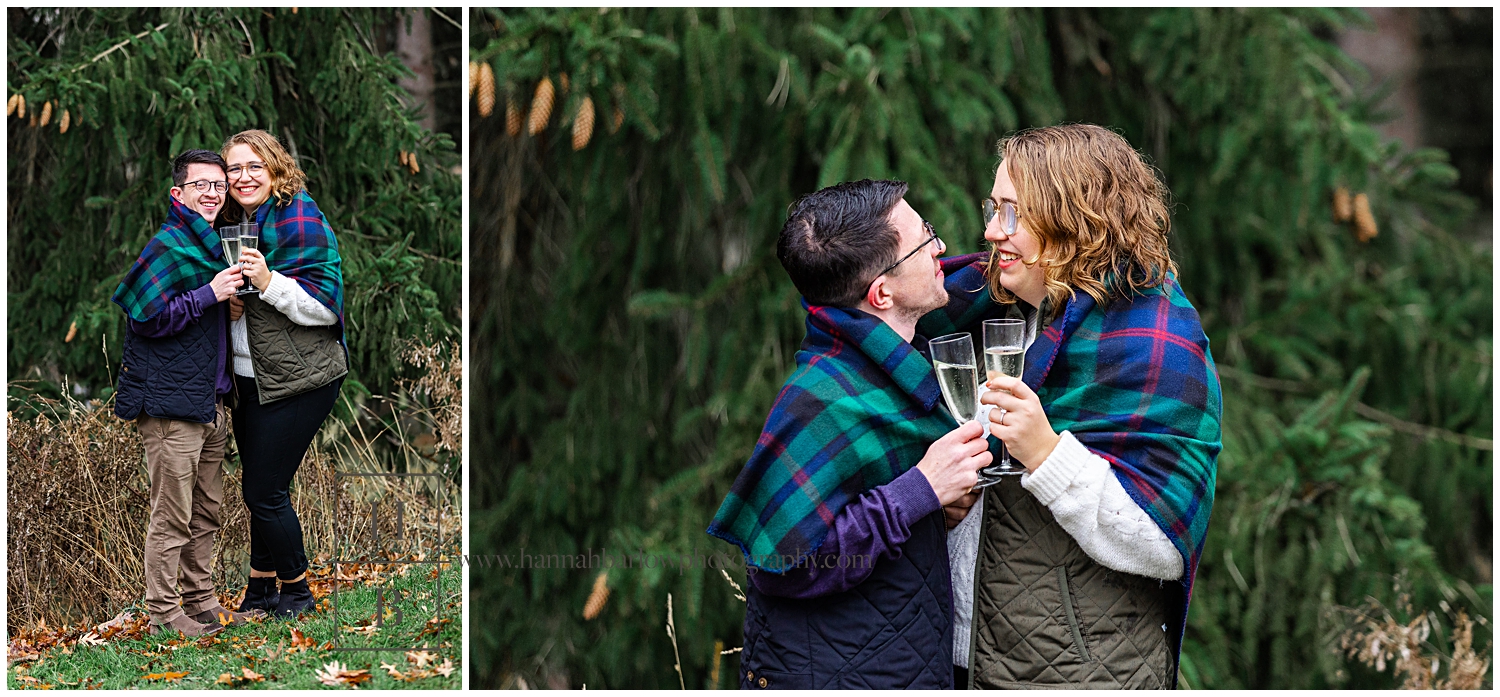 Couple embraces under flannel blanket for Christmas Engagement Photos