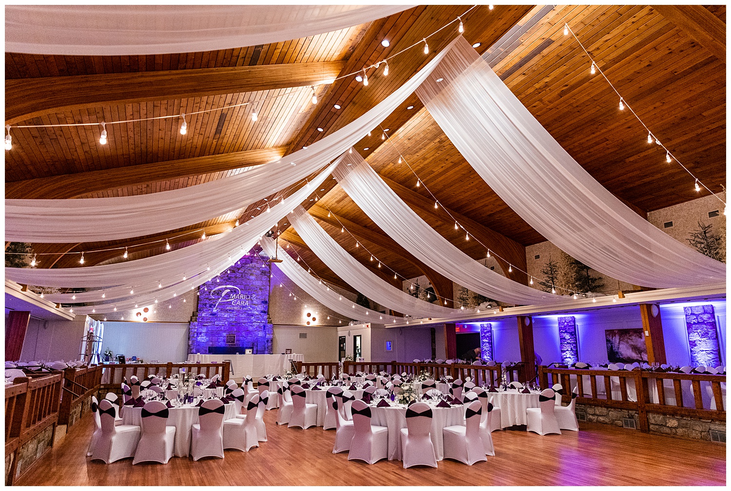 Purple uplighting and reception tables in Glessner Auditorium