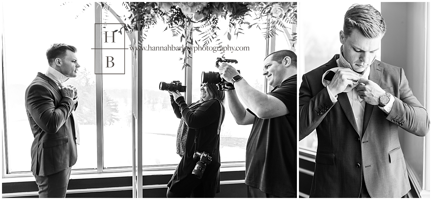 Black and white photo of wedding videographers photographing groom getting ready