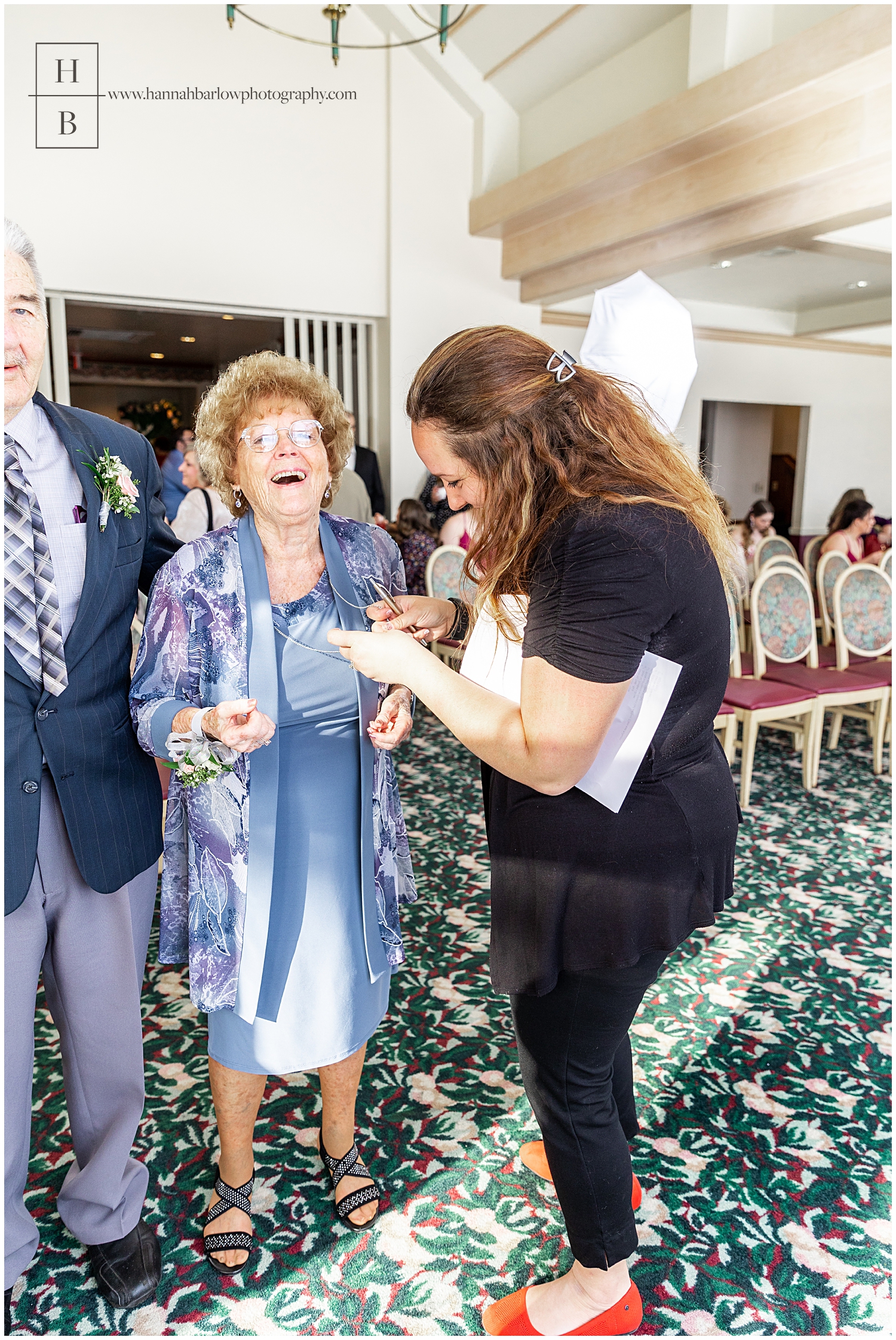 Wedding photographer helps laughing grandmother fix necklace