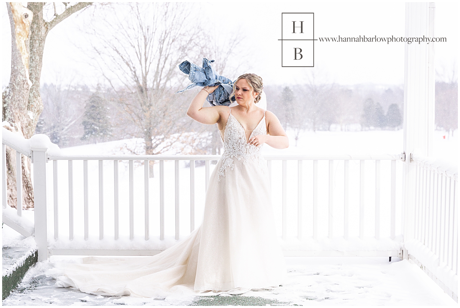 Bride in snowing wedding background throws jeans coat.