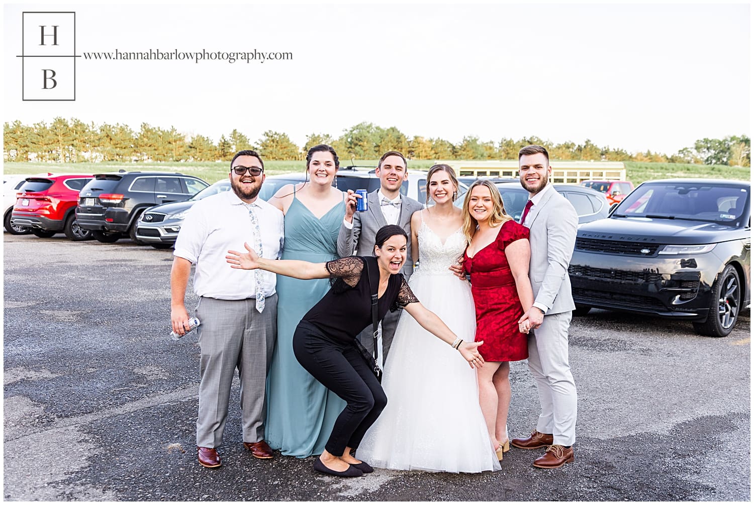 photographer poses with past couples who attend same wedding in parking lot of White Barn Prospect PA