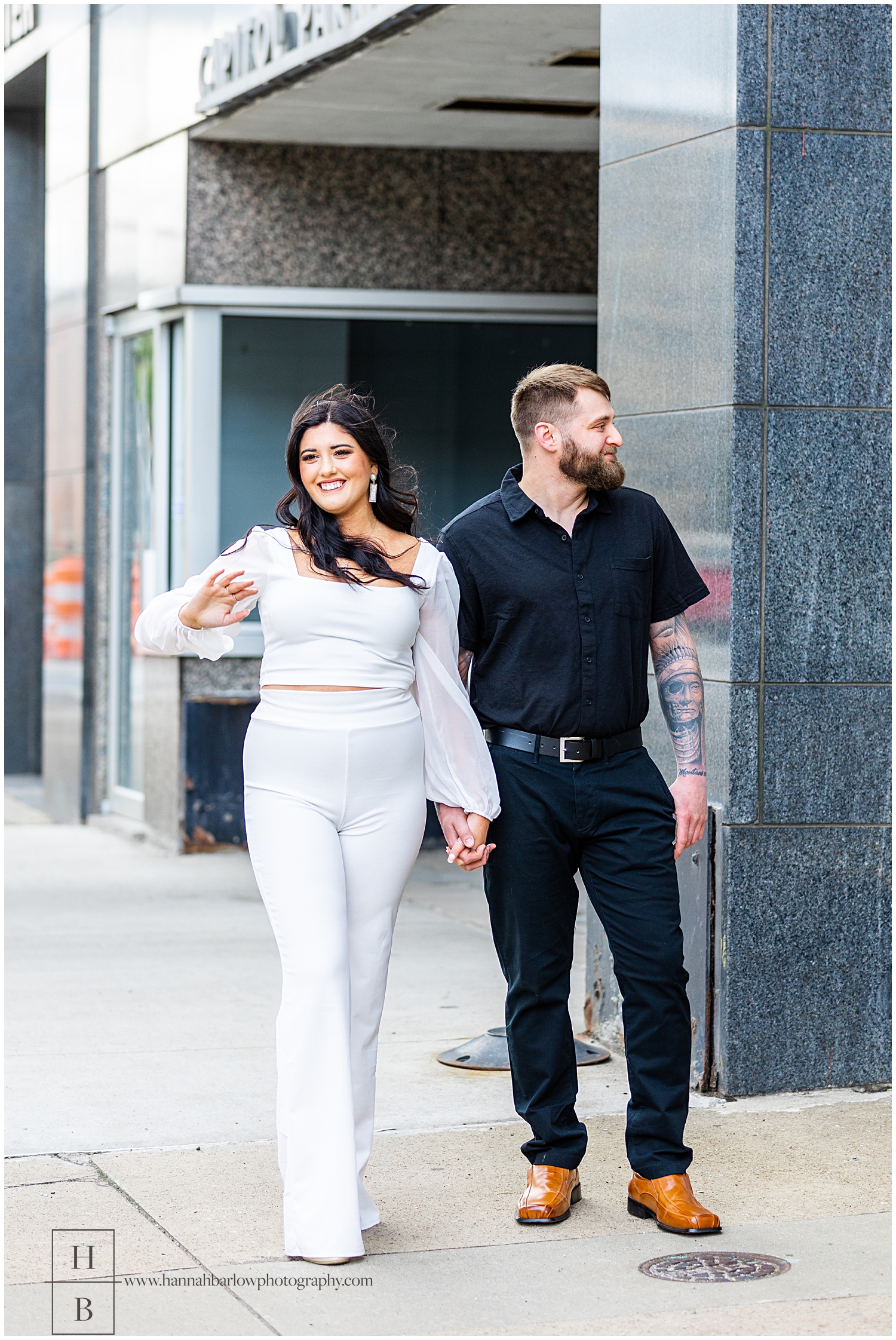 Couple walks down the sidewalk of Wheeling WV for engagement photos