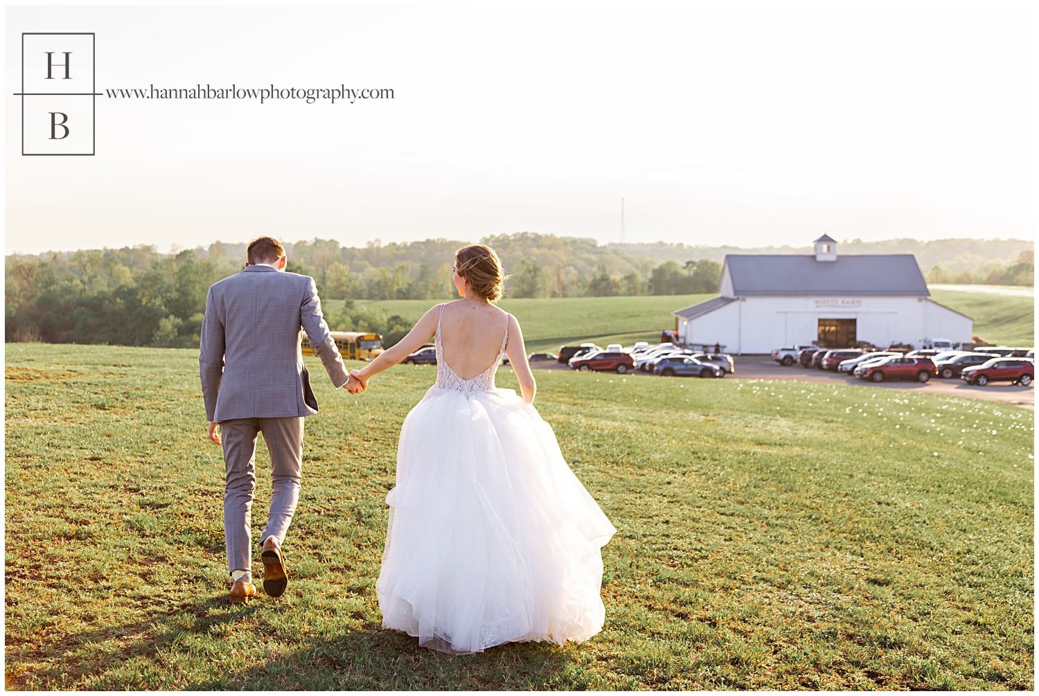 Couple runs toward their venue in field during Golden Hour.