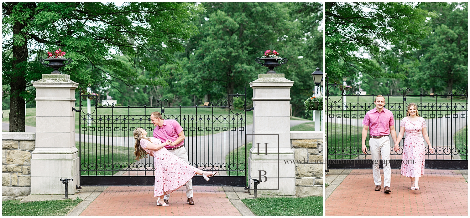Man and woman dance in front of black iron gates for engagement photos.