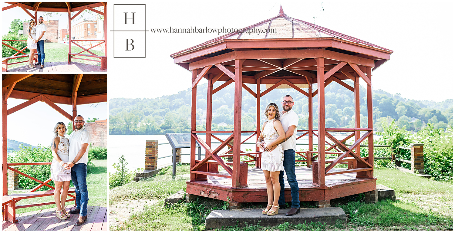 Couple poses by red gazebo for engagement photos.