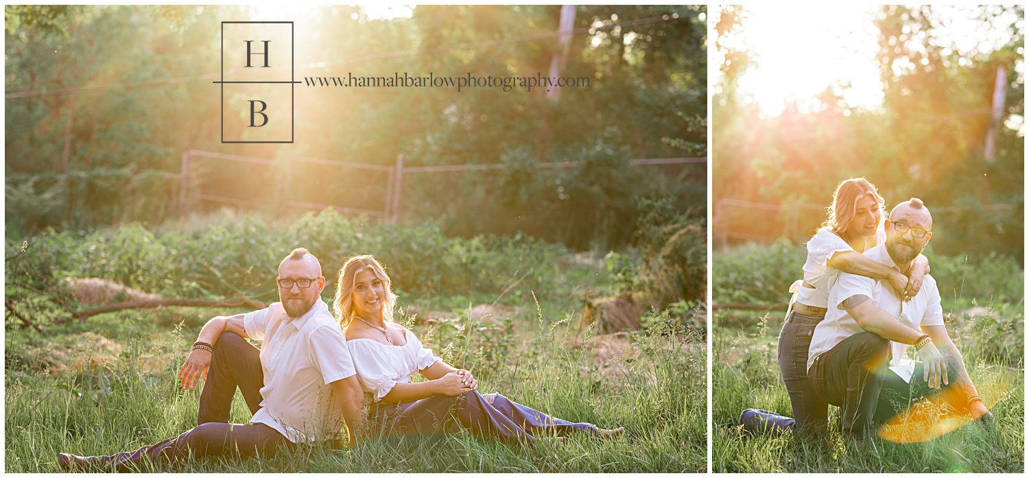 Couple poses in field by fence during golden hour.