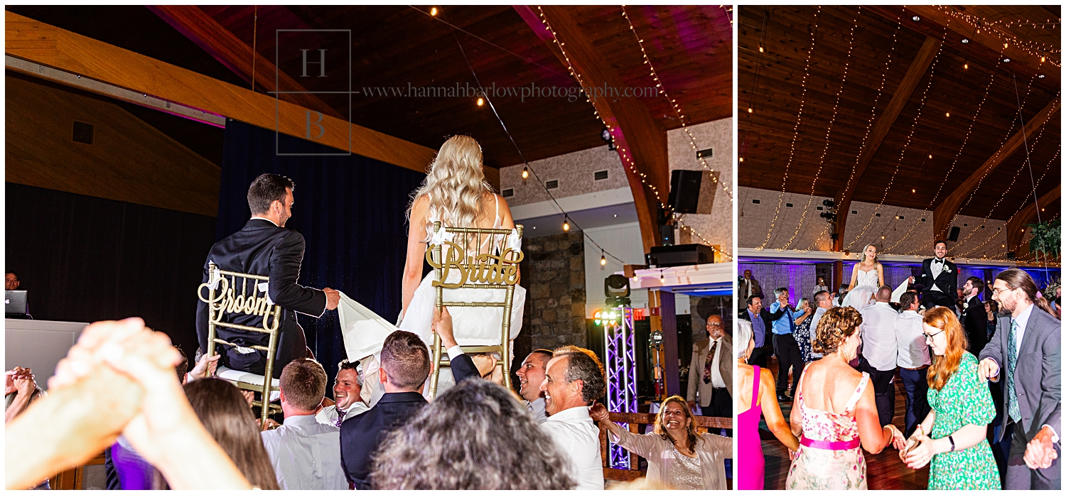 Bride and groom are held up on chairs as guests dance around them.
