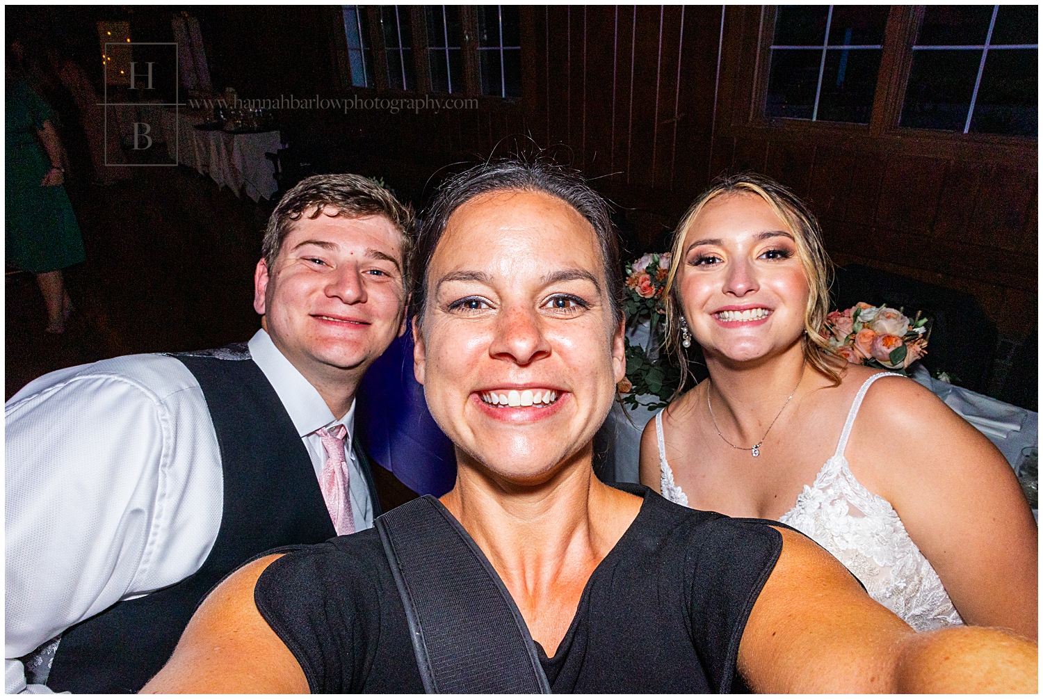 Photographer takes selfie with bride and groom