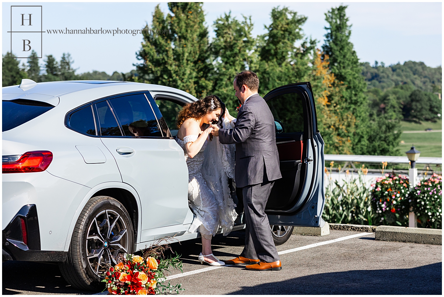 Groom helps bride out of grey BMW car.