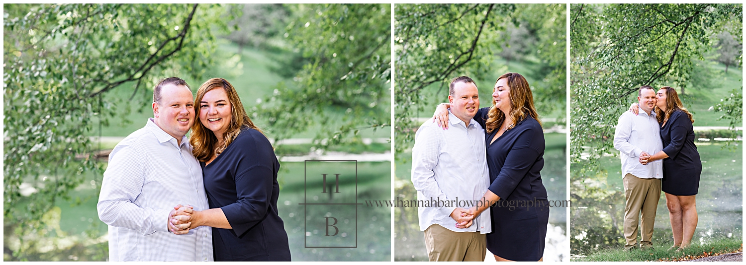 Lady in navy dress embrasses fiance by lakeside for engagement photos.