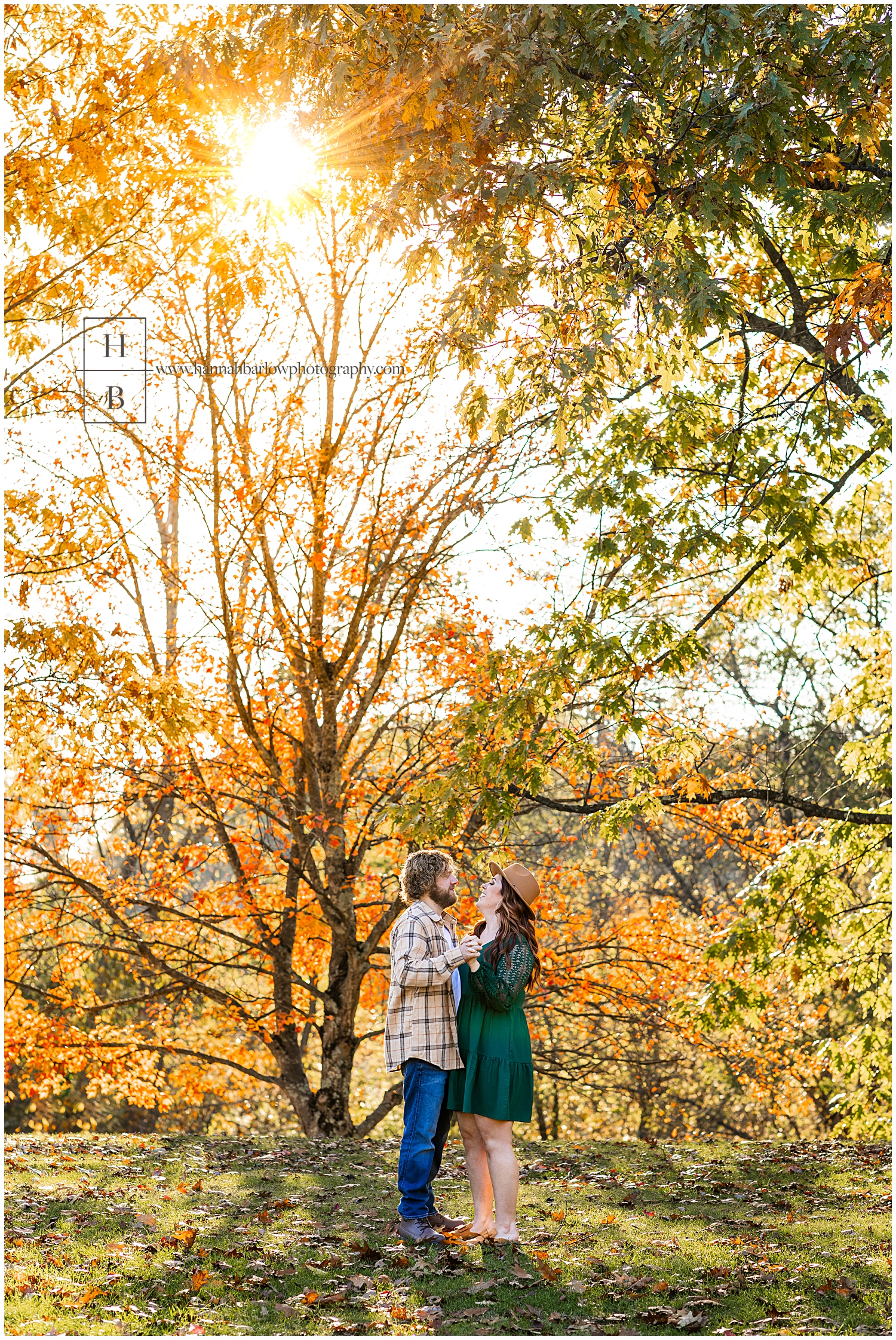 Couple stands in front of colorful trees and dance.