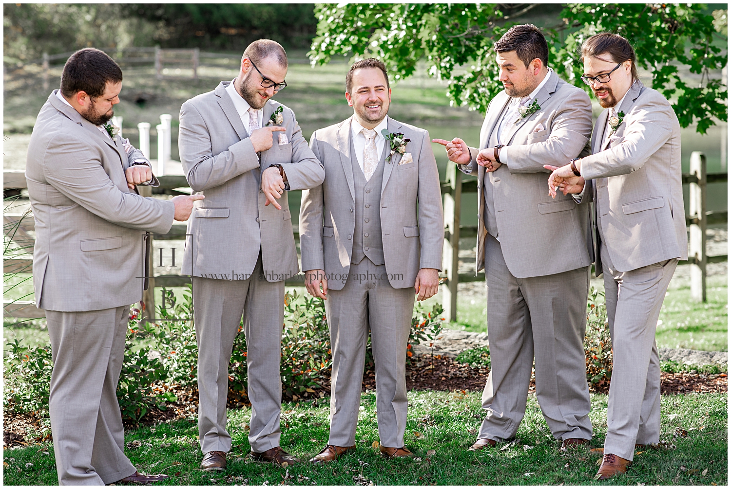 Groomsmen point at watches and groom.