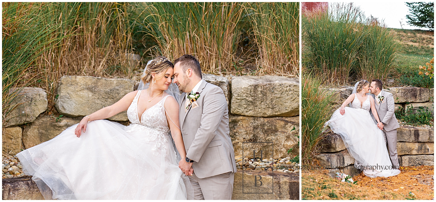Bride sits on stones and embraces groom for photos.