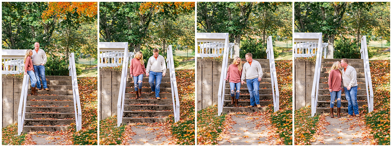 Couple walks down stone stairs with fall leaves in the background.