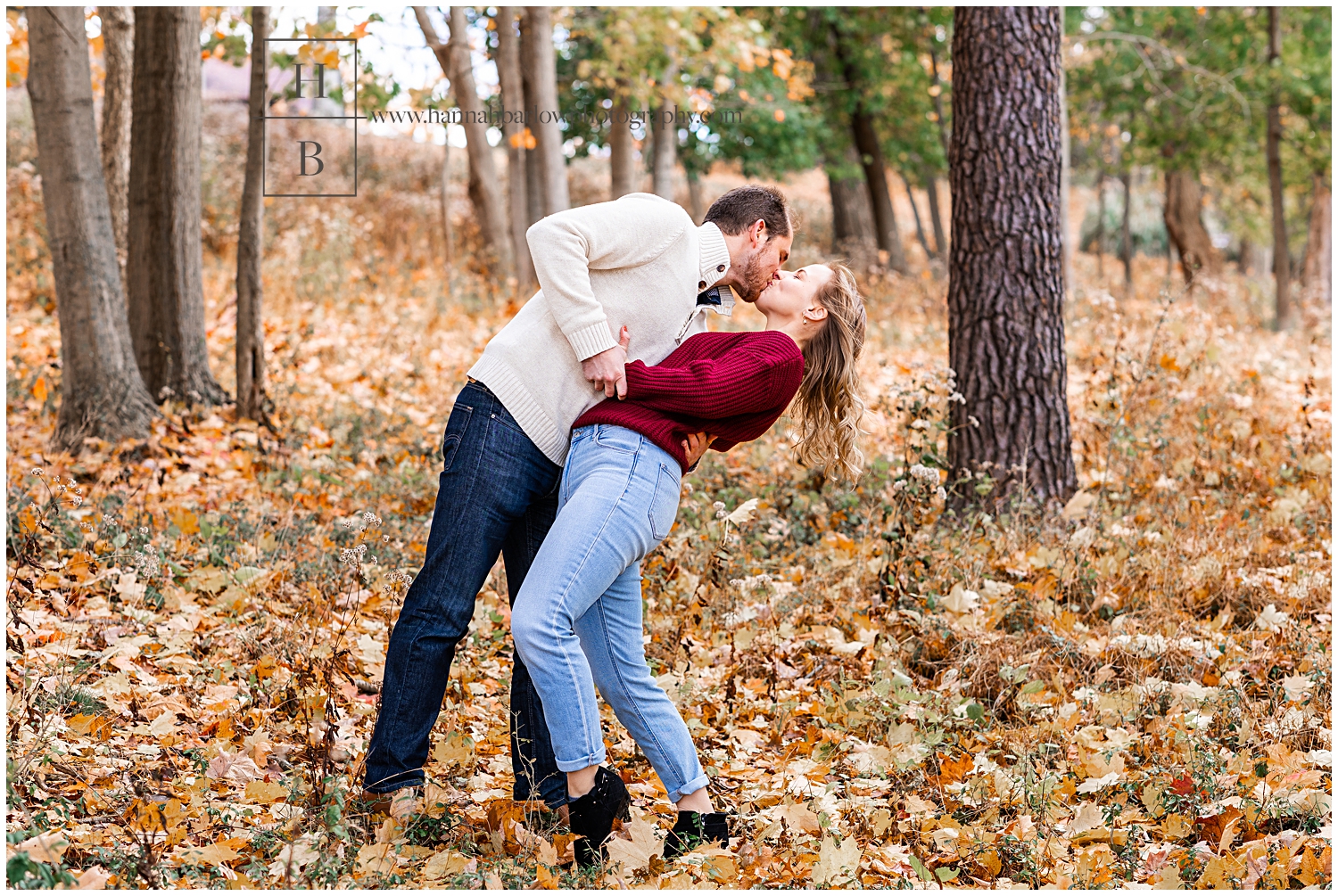 Man dips woman standing in orange fall leaves for a kiss.