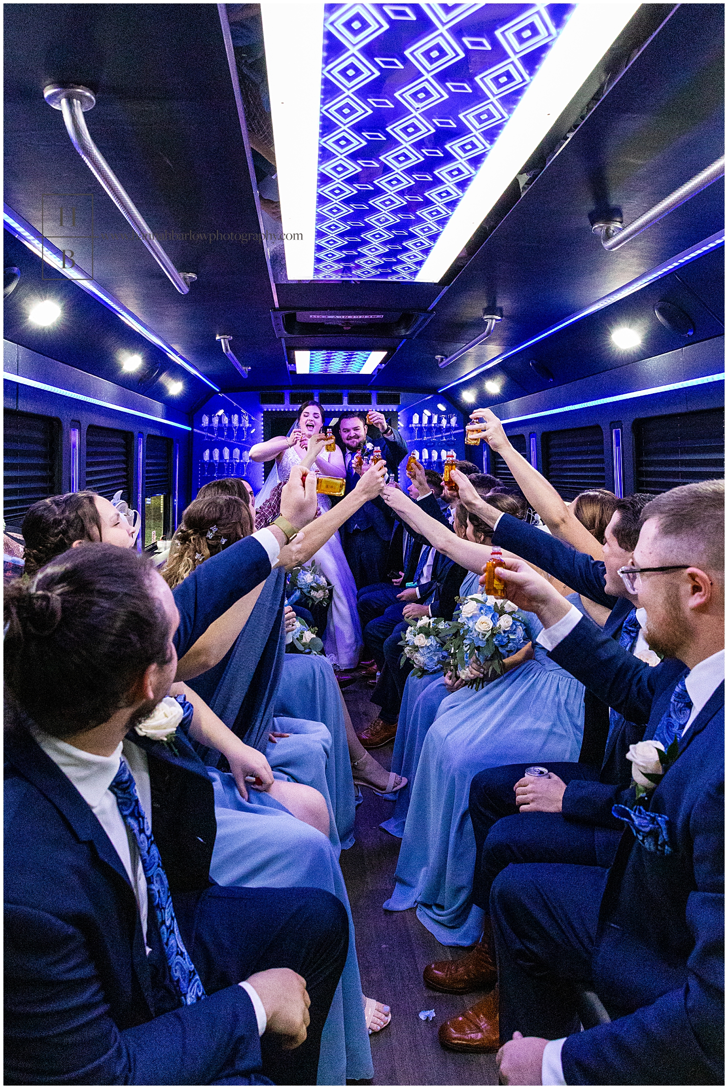 Couple in blue lighted limo hold up shots and cheer