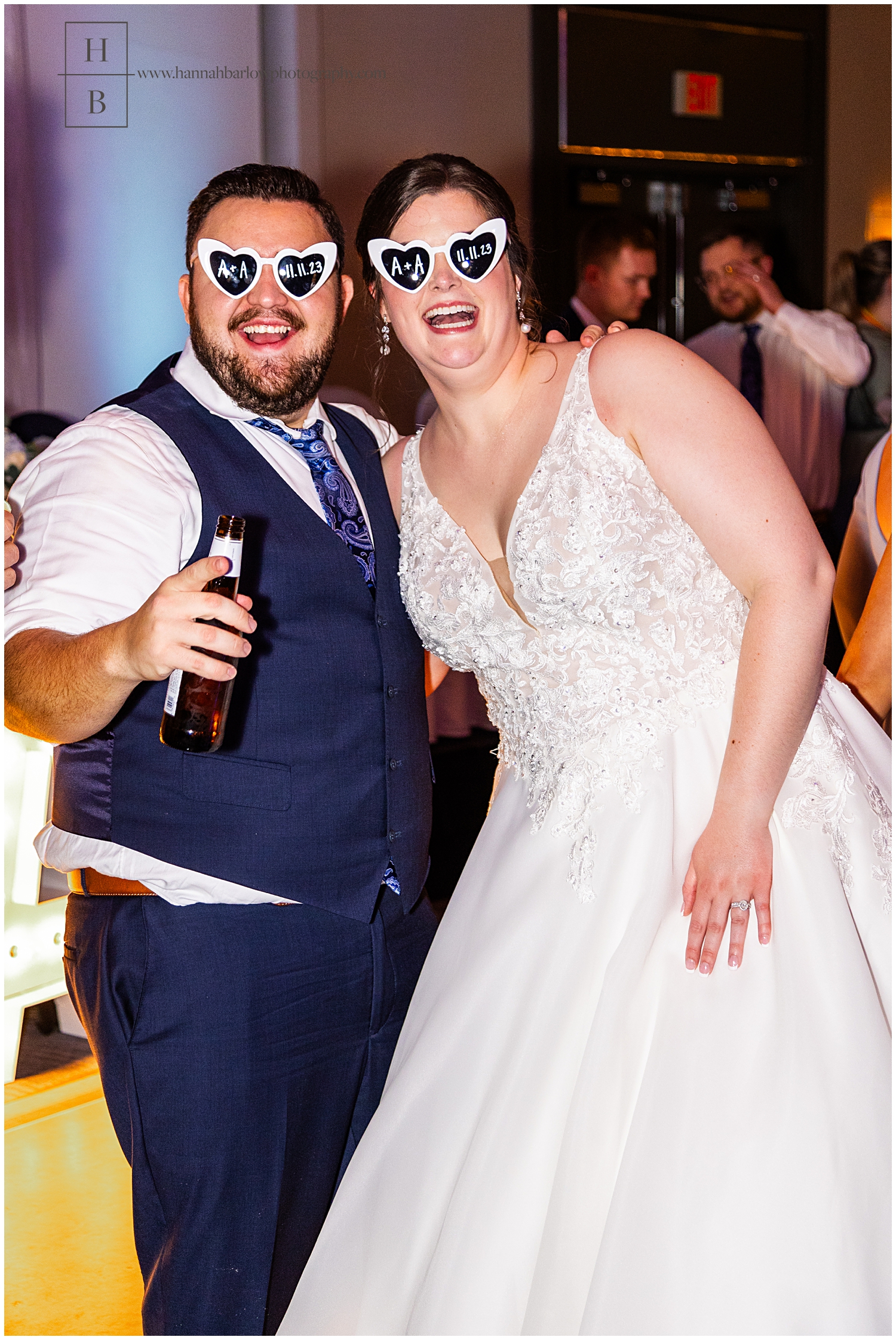 Wedding couple wears white heart glasses with initials and wedding date on dance floor 