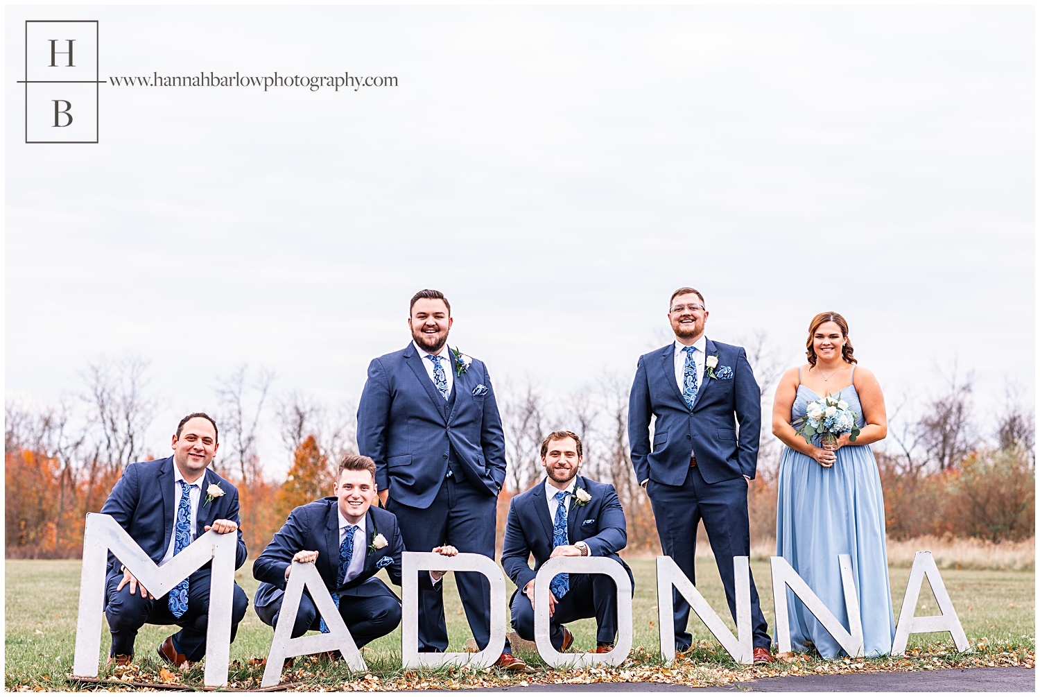 Bridal party members pose by high school Madonna sign