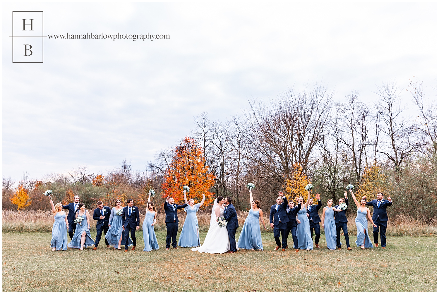 Bridal party wearing blue walks with bride and groom and cheers