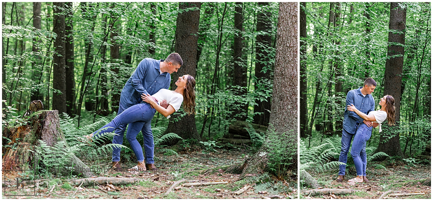 Man dips woman in forest for engagement photos