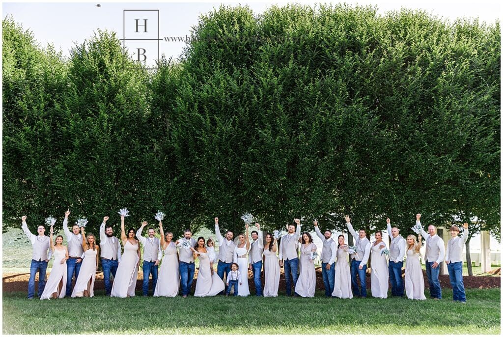 large bridal party walks on treeline