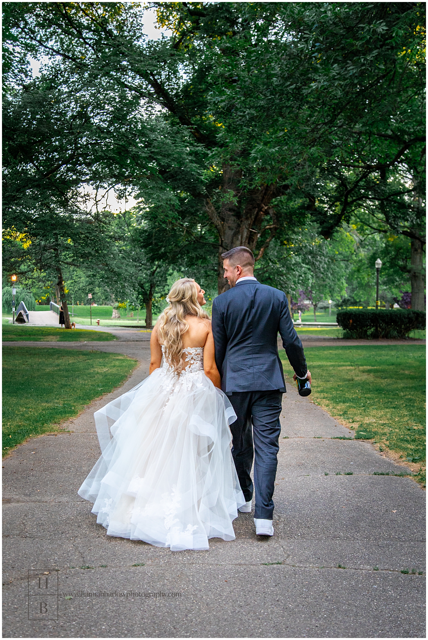 Groom walks with bride in park