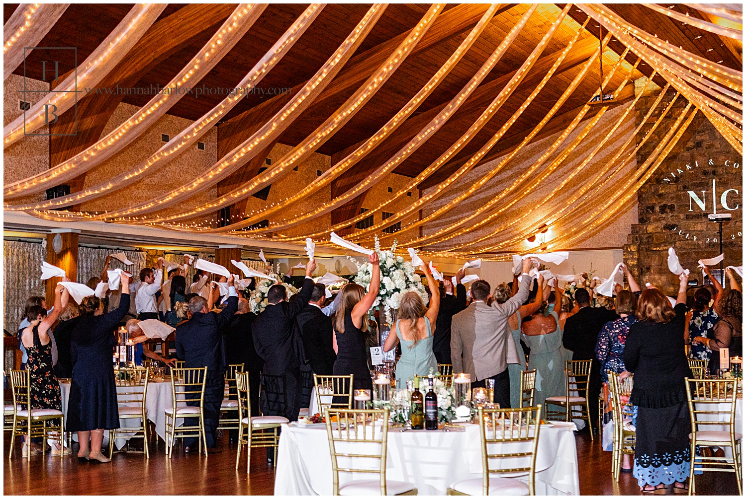 Guests wave wedding napkins as couple enters reception