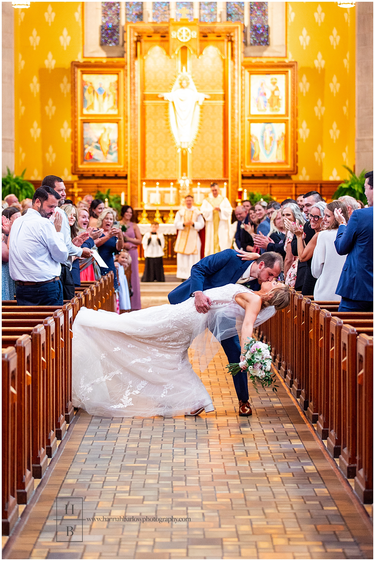 Groom dips bride at end of church aisle