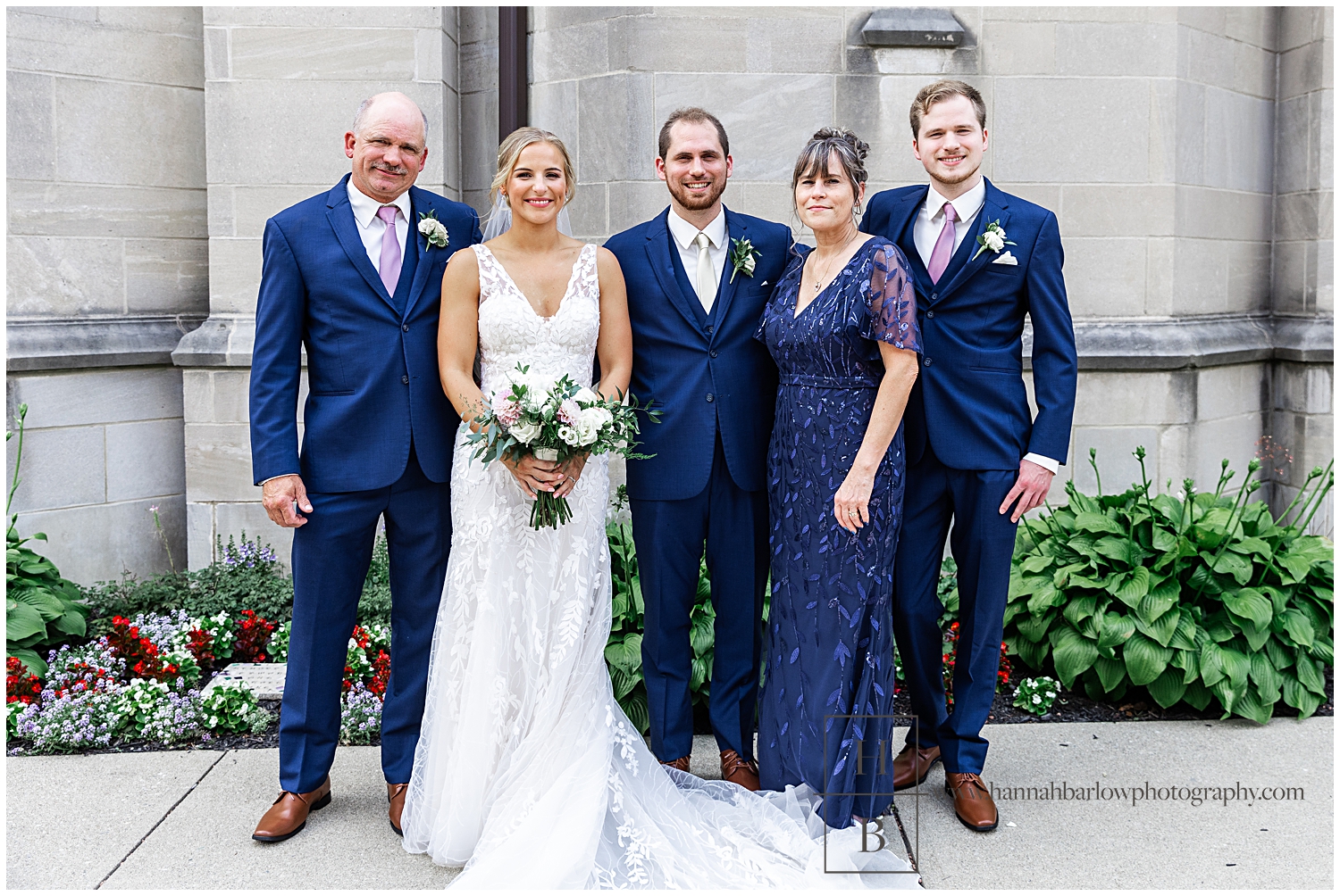 Groom poses with family outside