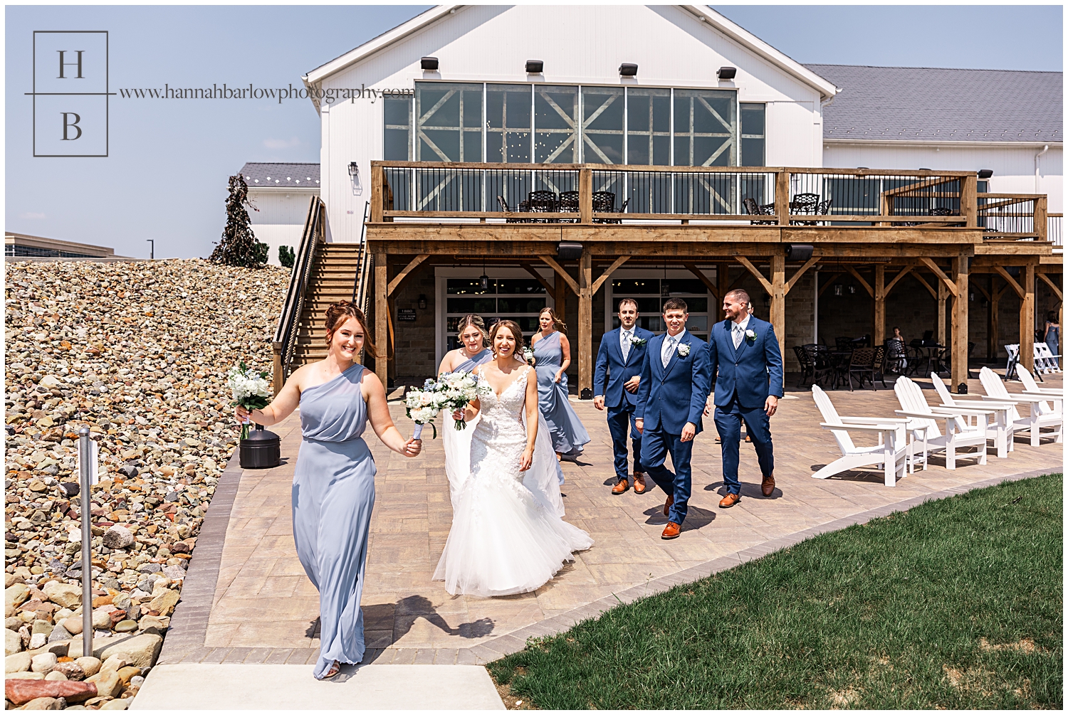 Bridal party walks with bride and groom in front of venue