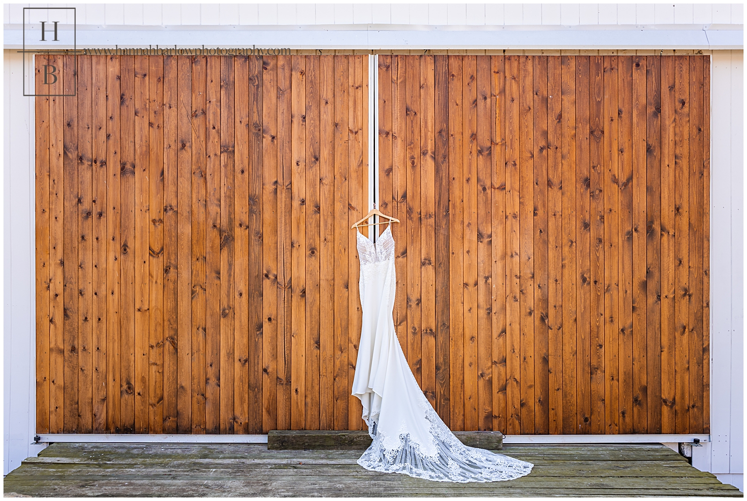 Wedding dress hangs on large brown barn doors