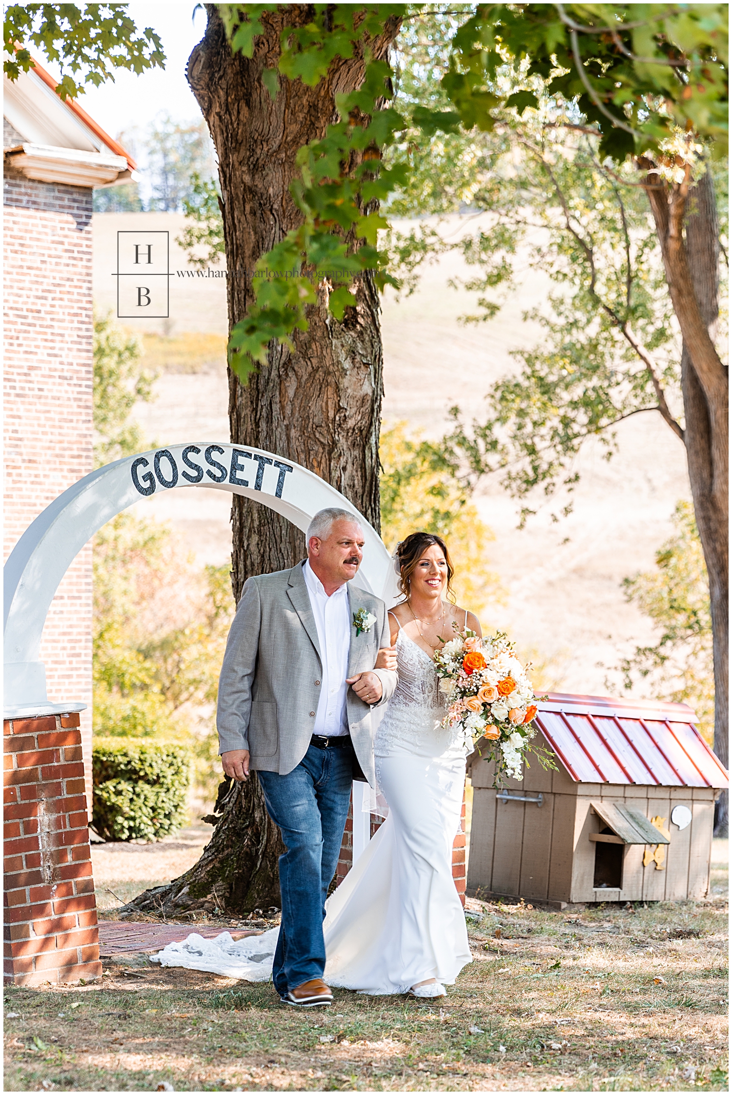 Dad walks bride down the aisle with last name on arch in background