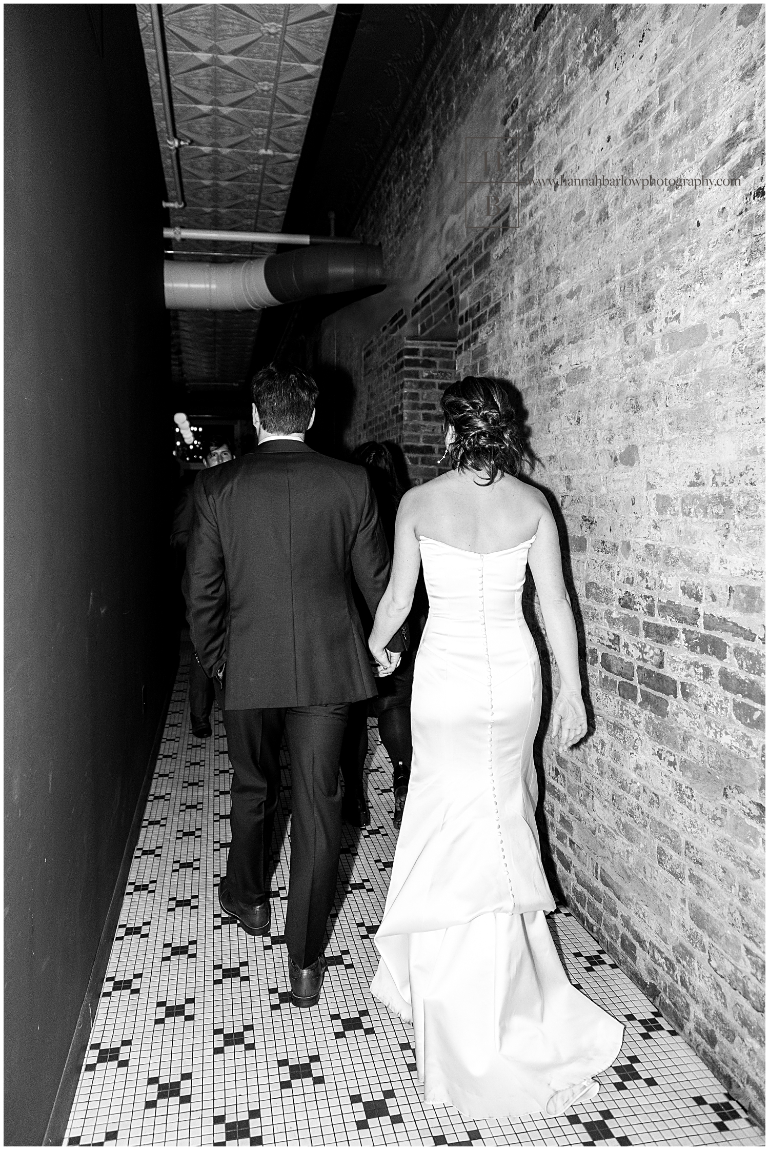 Bride and groom walk away from reception in black-and-white