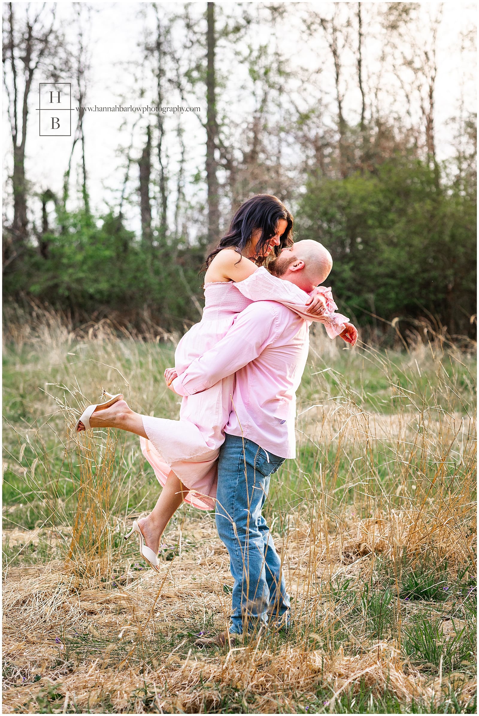 man picks woman up for engagement photo
