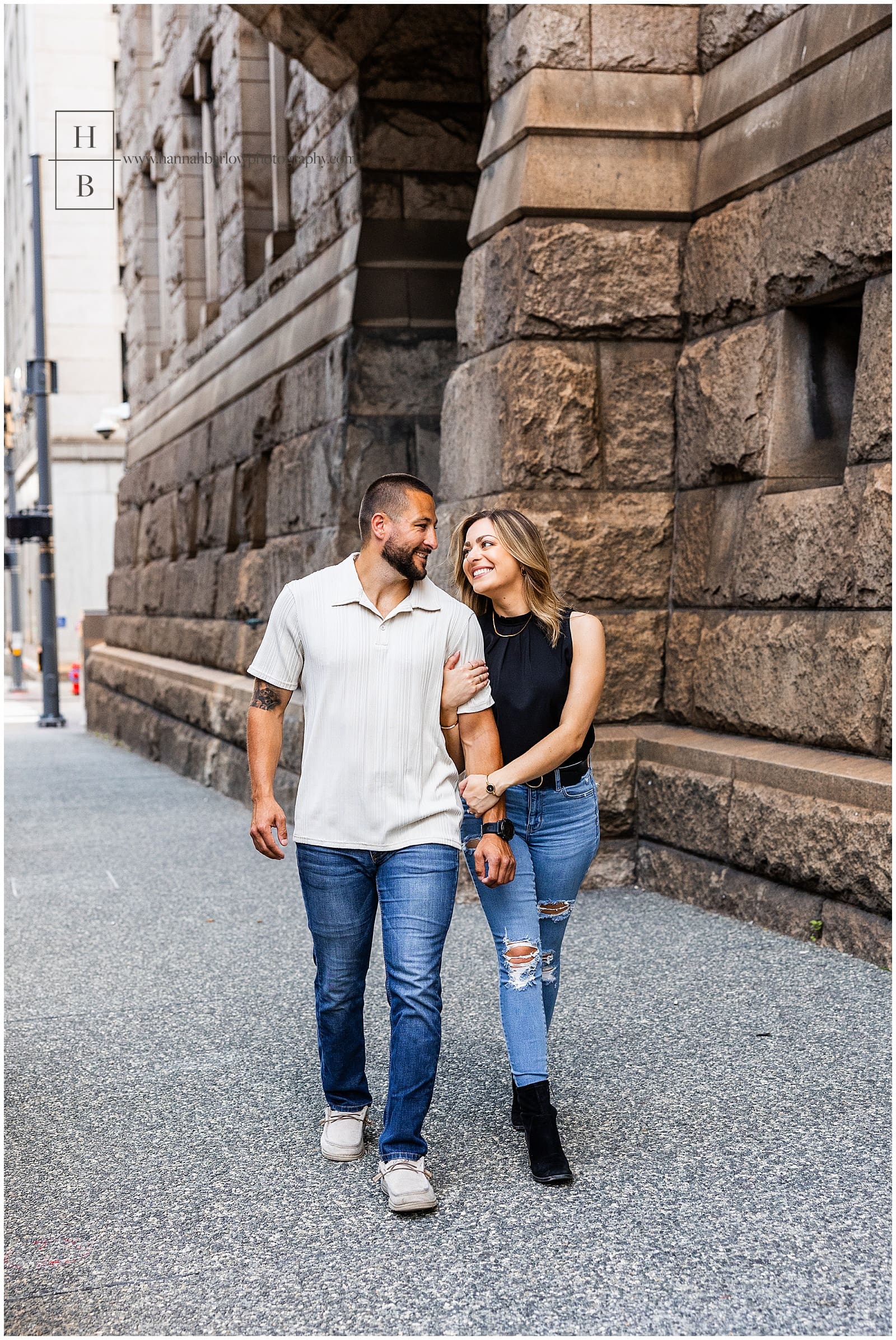 couple walks down sidewalk in pittsburgh outside allegheny county courthouse