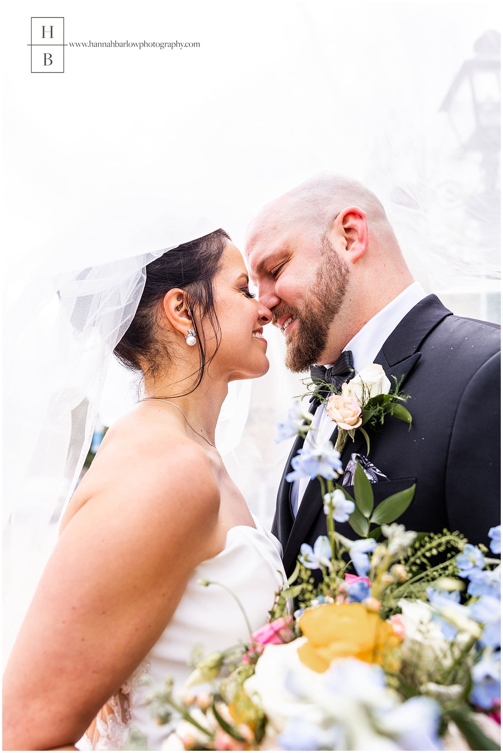 Bride and groom kiss under veil
