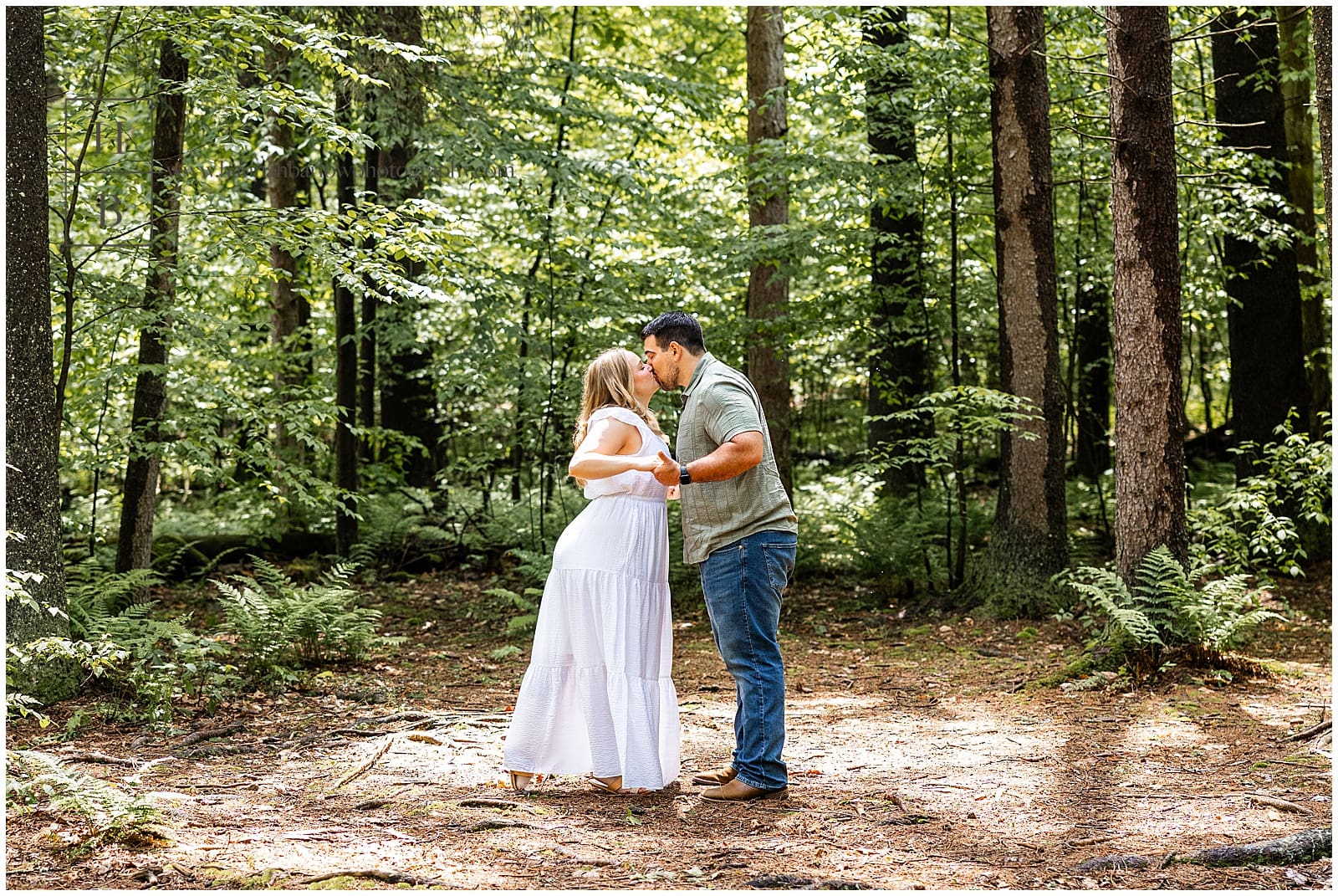 couple leans in to kiss in forest