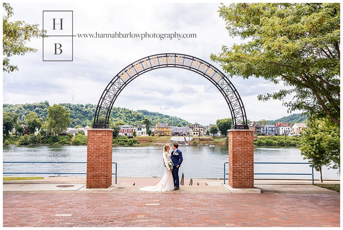bride and groom pose by heritage port sign