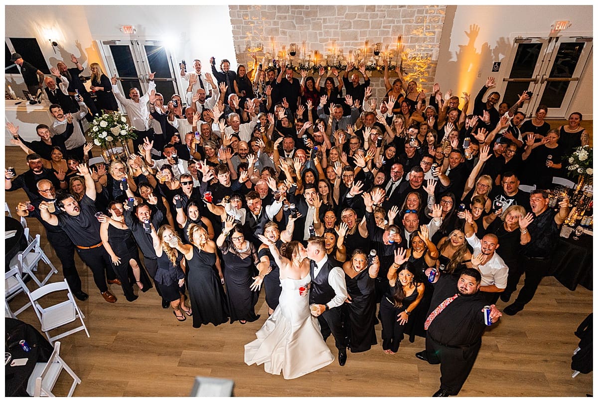 couple and guests fill dance floor for large group photo