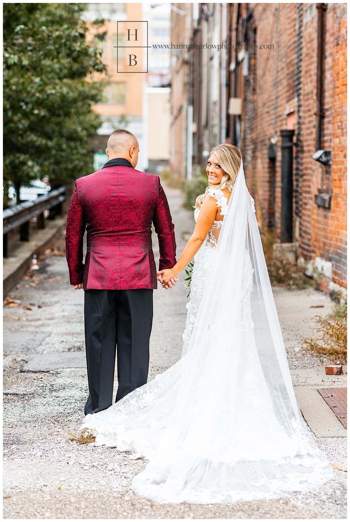 bride and groom walk down alley bride looks back