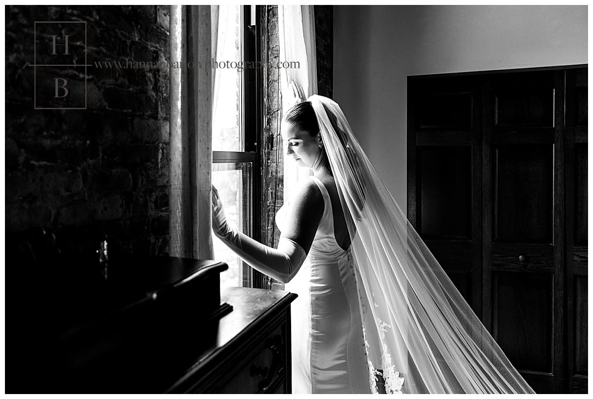 black and white photo of bride at window
