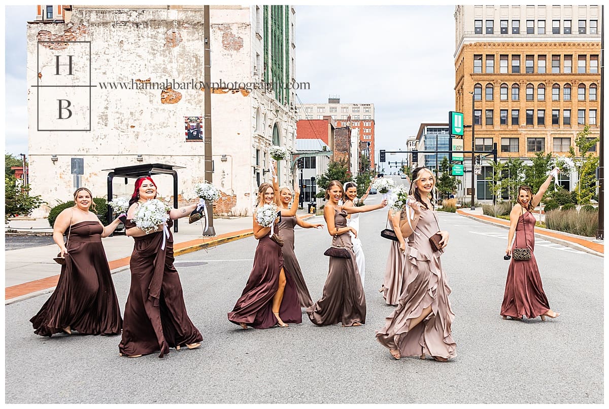 bridesmaids in brown dresses walk across street smiling