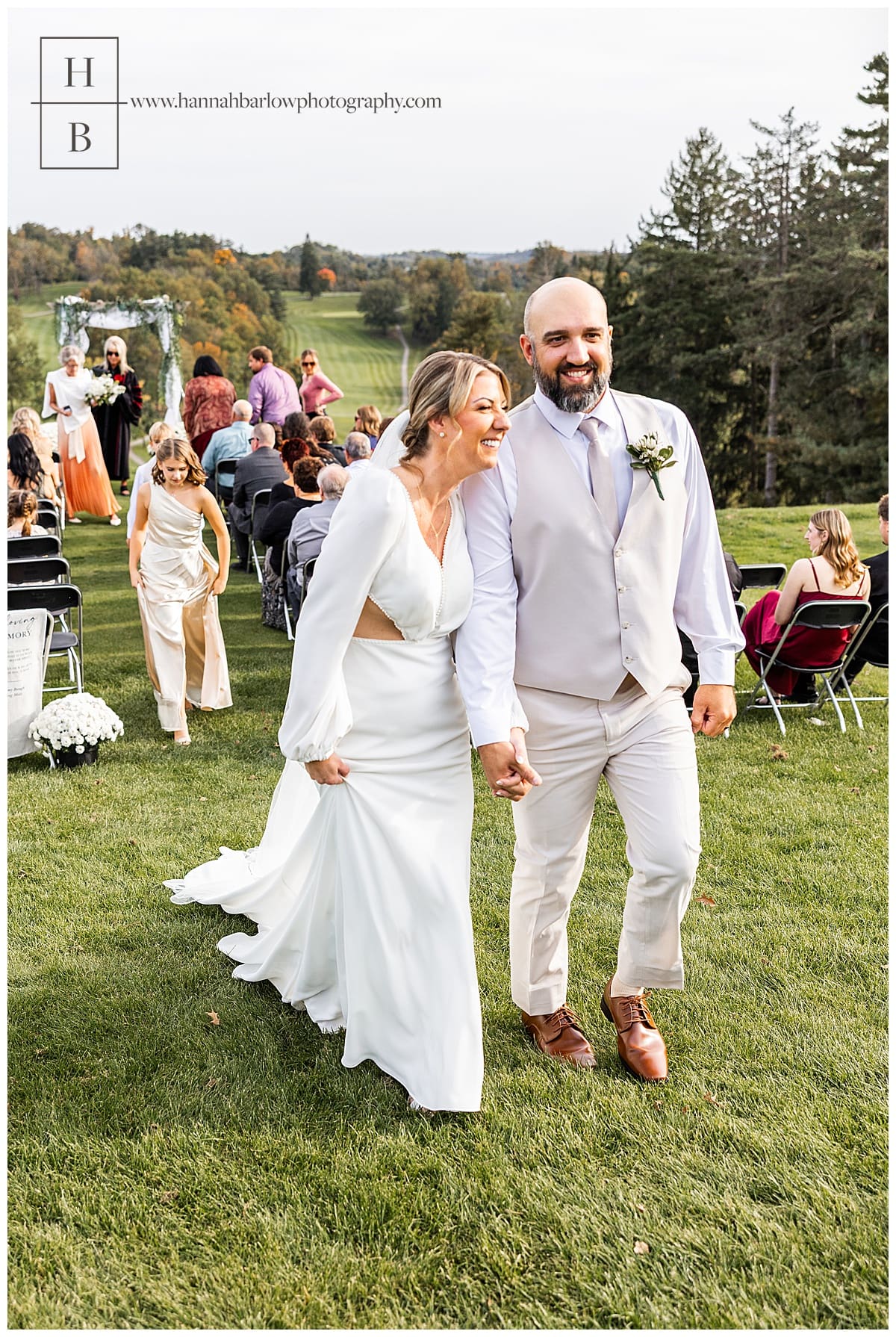 bride and groom smile and laugh while walking back down aisle after being married